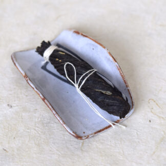 gedroogde zwarte theeblaadjes opgerold opeen keramieken schaaltje